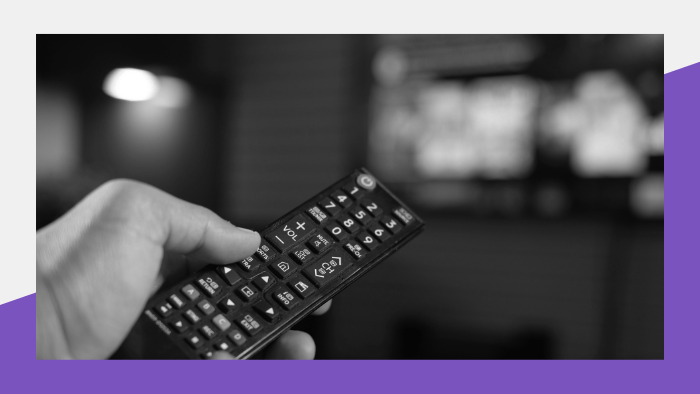 Person pointing a remote control at a TV