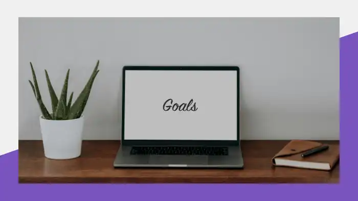 Open laptop on a desk with "Goals" written on the screen