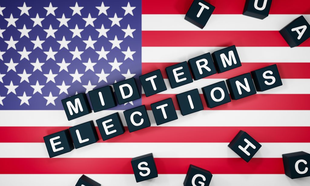 American flag with block letters overlaid that spell out "midterm elections"