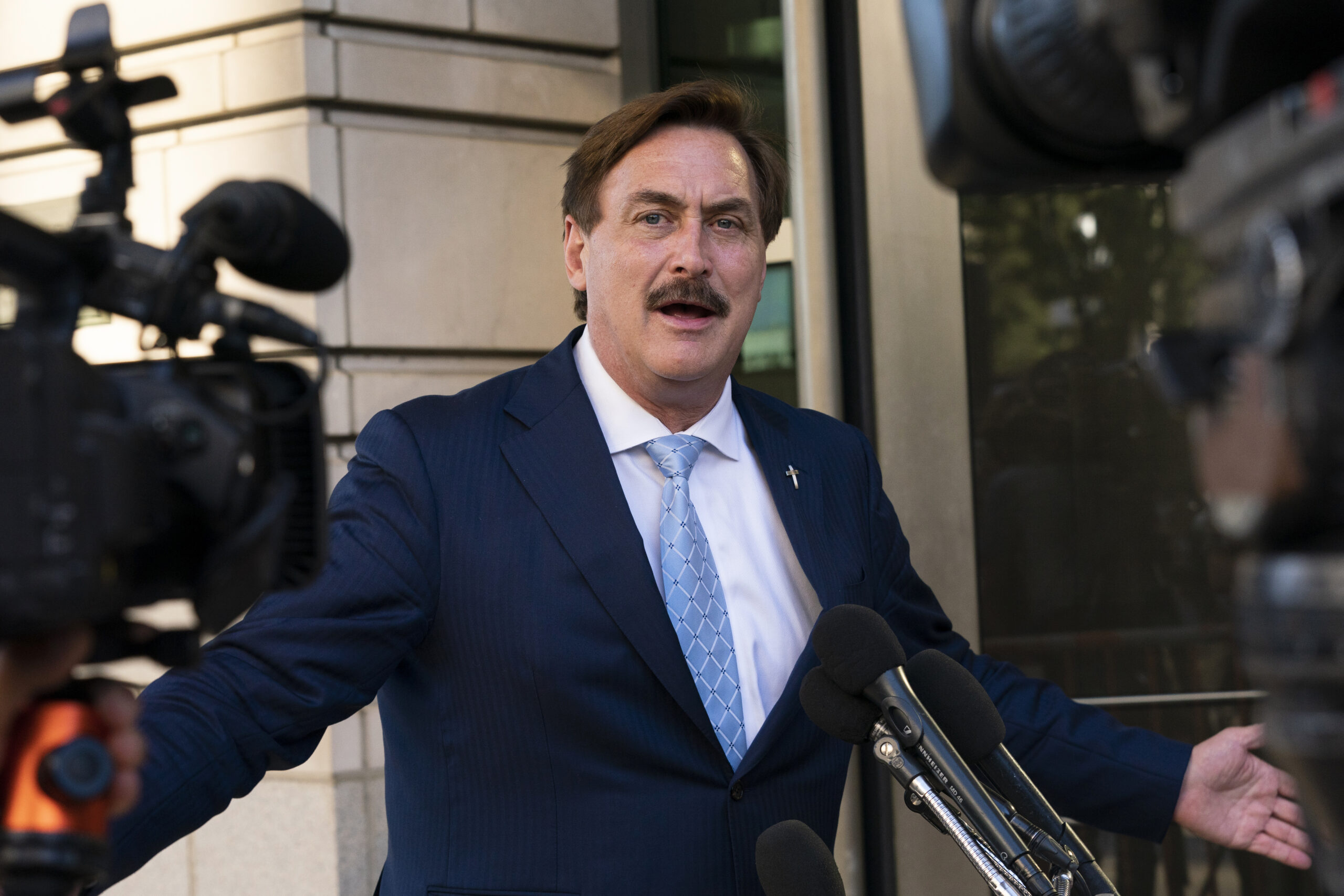 Mike lindell talking to reporters outside a courthouse