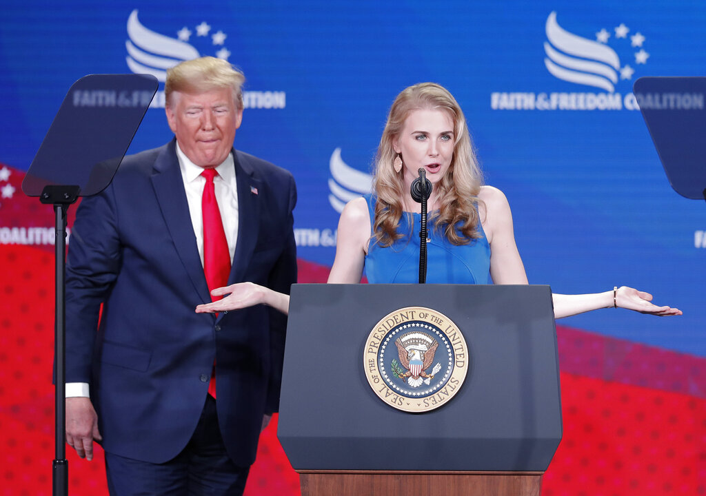 President donald trump, left, listens natalie harp, right, speak after inviting her on stage at the faith & freedom coalition conference in washington, wednesday, june 26, 2019.