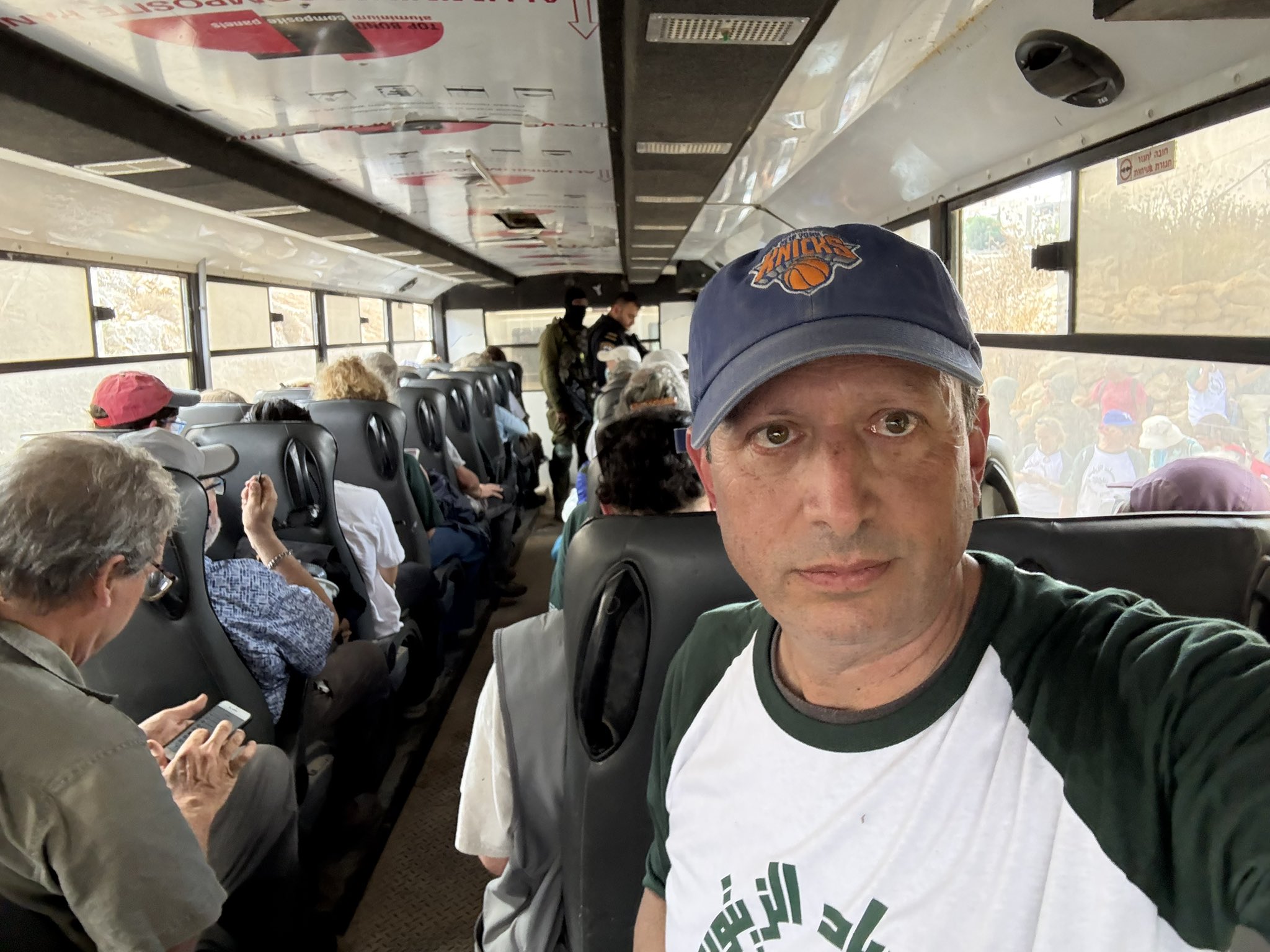 Brad lander in a knicks hat on a bus taking a selfie