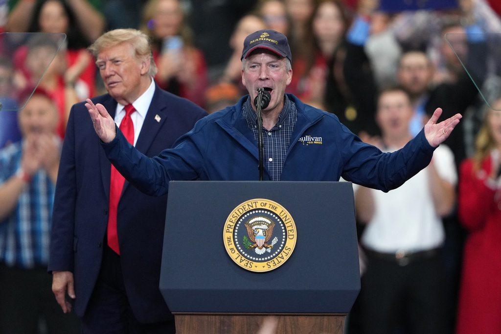 Daniel s. Sullivan at podium at trump rally with trump behind him